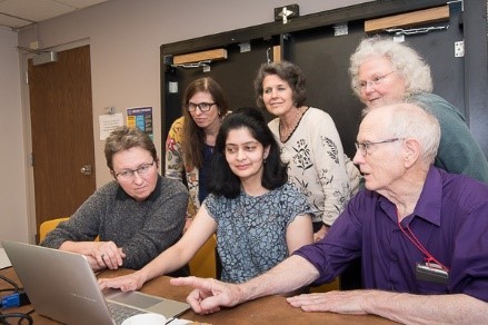 Project team collaborating around a laptop computer